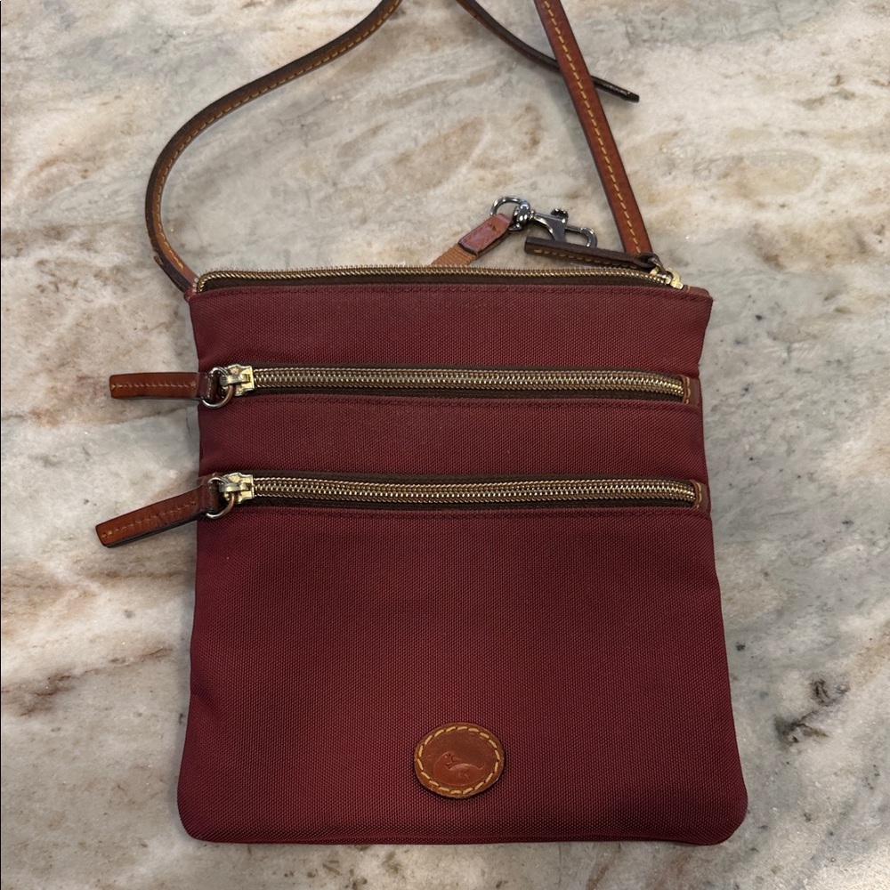 Dooney & Bourke North South Triple Zip crossbody bag in cranberry nylon
